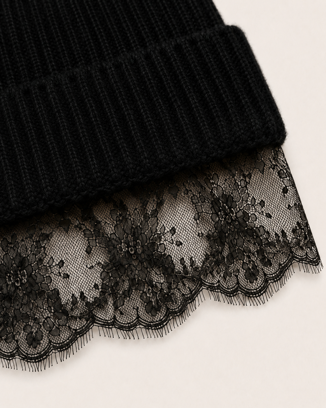 Dettaglio del berretto Cashmi in cashmere nero con visiera in pizzo floreale