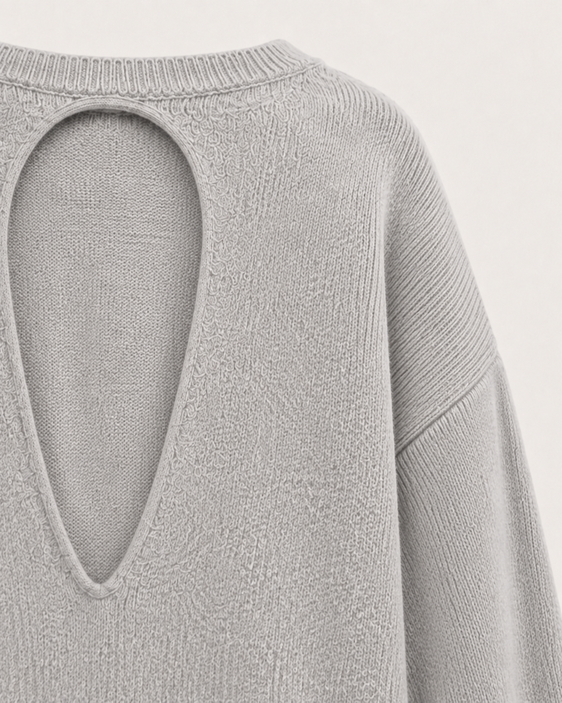 Dettaglio dell’apertura a goccia sul retro del maglione in cashmere grigio