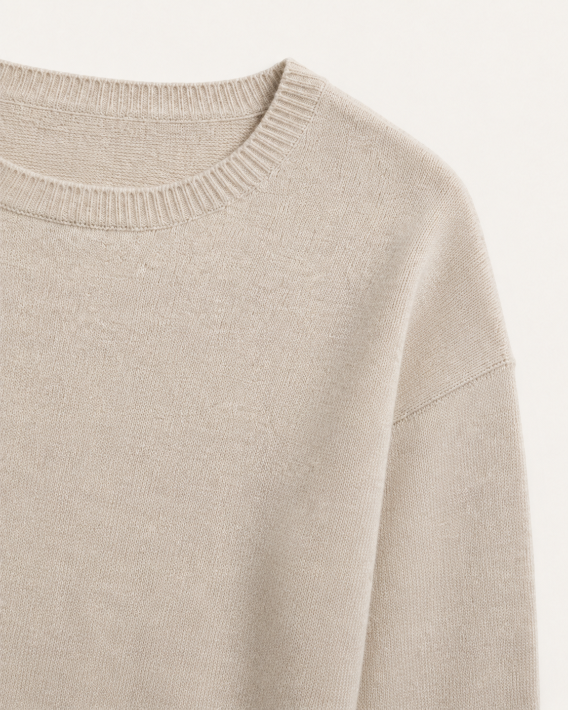 Dettaglio del girocollo e della spalla scesa del maglione Cashmi beige con maniche a tre quarti.