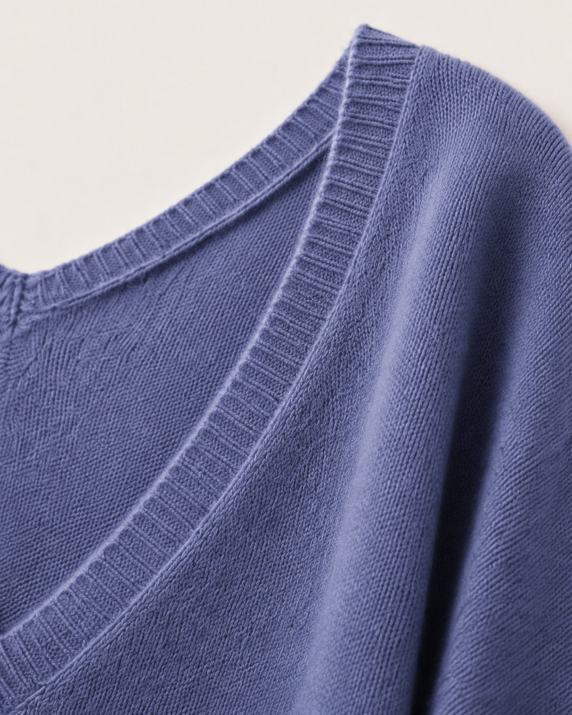 Dettaglio degli ampi scolli a V e del soffice filato in cashmere blu