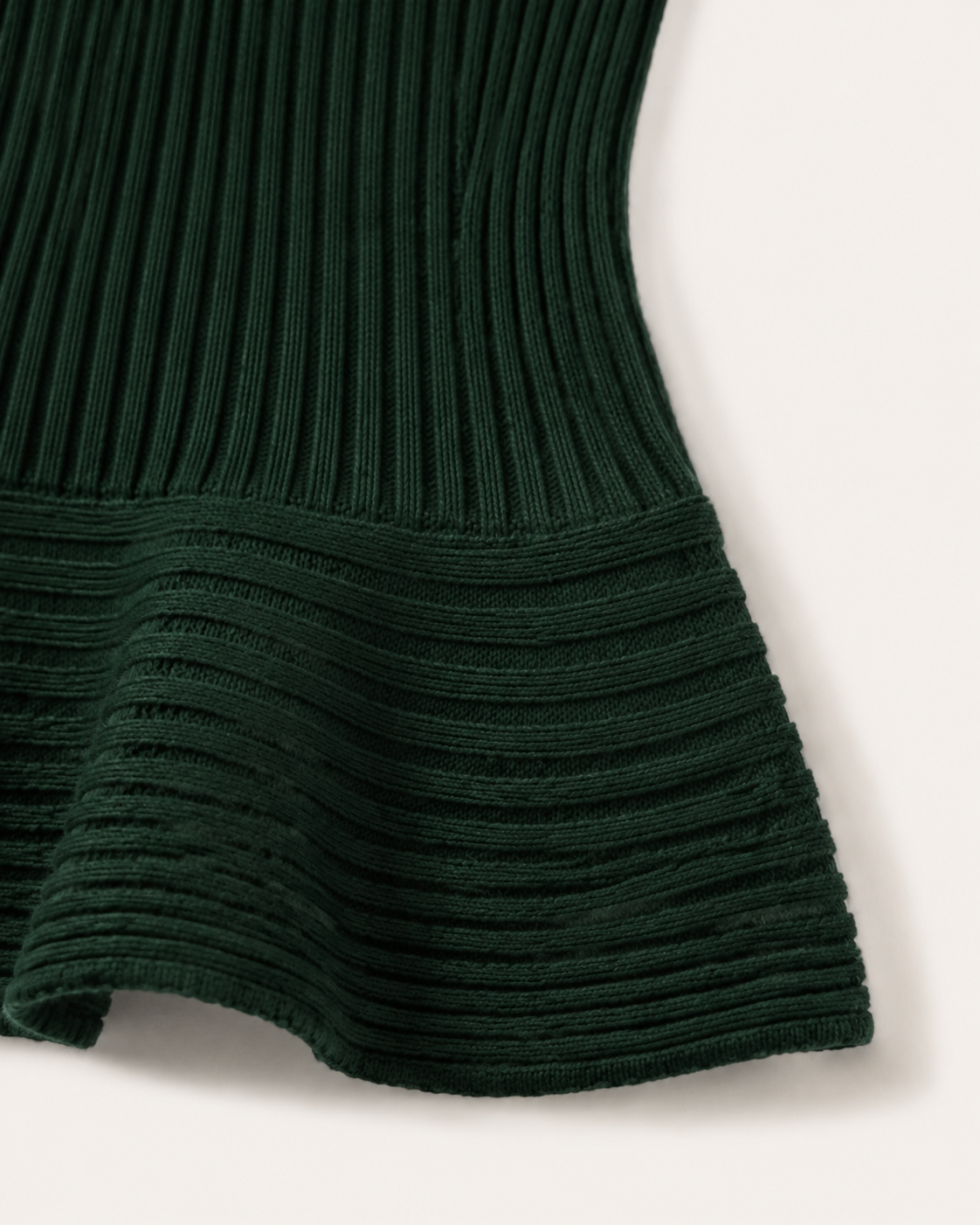 Dettaglio posteriore della baschina a coste orizzontali del maglione smanicato Cashmi verde bosco in cashmere.