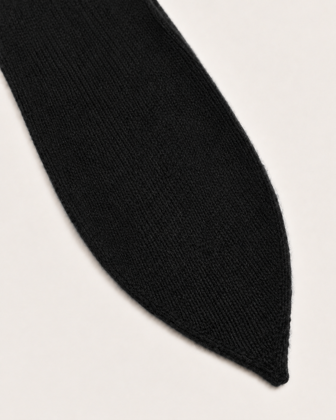 Dettaglio dell’estremità della sciarpa cravatta Cashmi in cashmere nero.