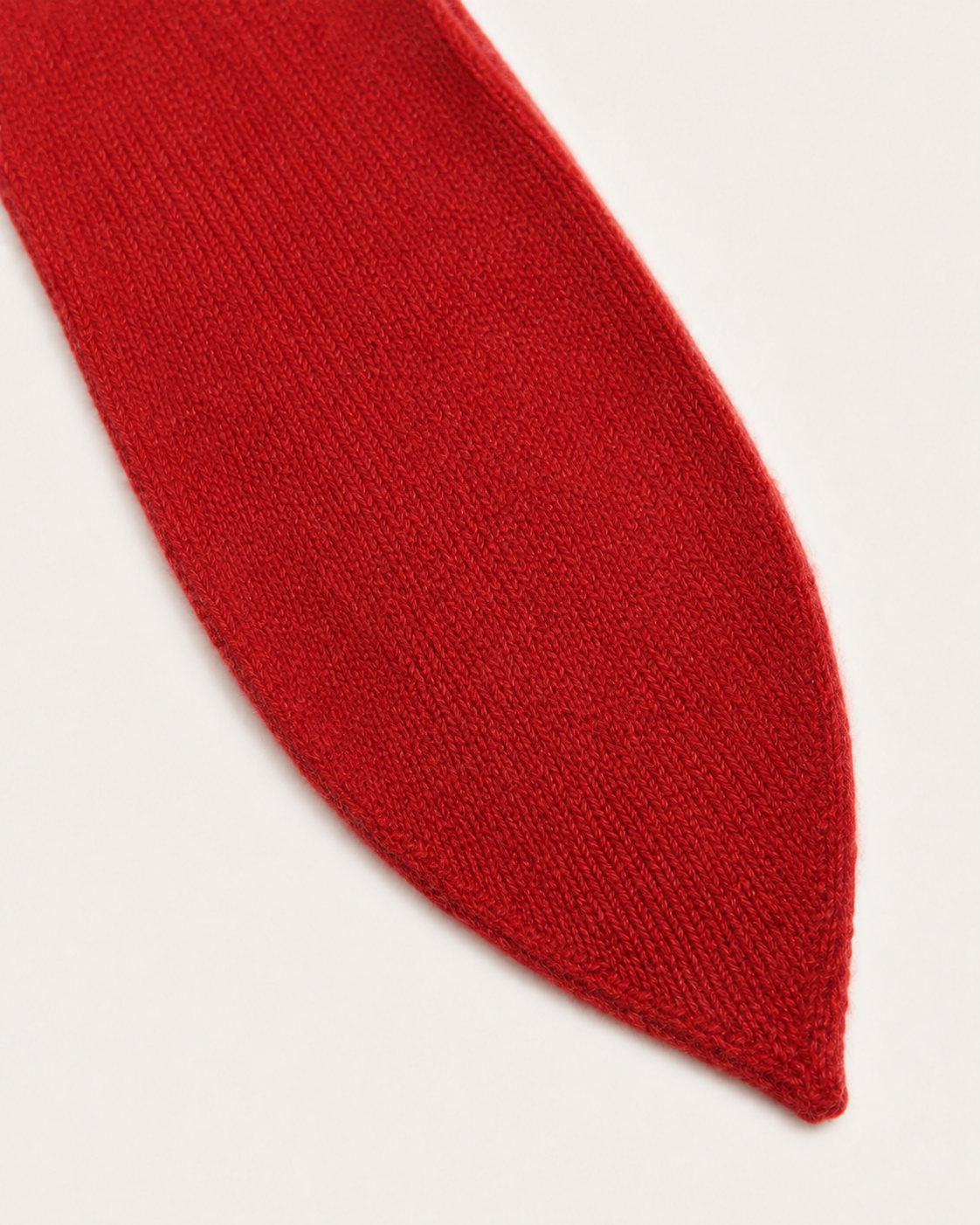 Dettaglio dell’estremità della sciarpa cravatta Cashmi in cashmere rosso.