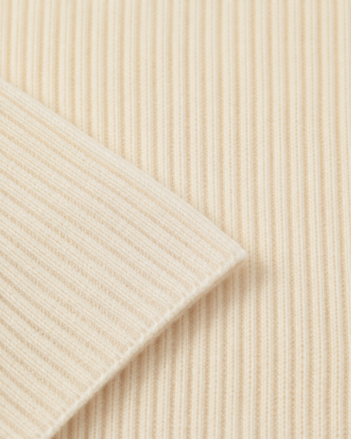 Dettaglio della lavorazione a maglia inglese della sciarpa Cashmi in cashmere color panna.